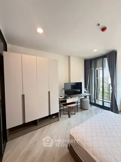 Modern bedroom with large windows and stylish furniture in a high-rise apartment.