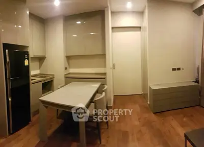 Modern kitchen with sleek cabinetry and dining area in contemporary apartment.