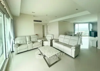 Spacious modern living room with white leather sofas and panoramic windows
