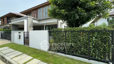 Modern house exterior with lush garden and sleek fence design