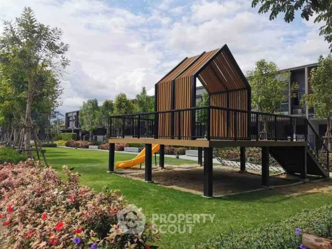 Modern playground in a landscaped garden setting with lush greenery and contemporary design.
