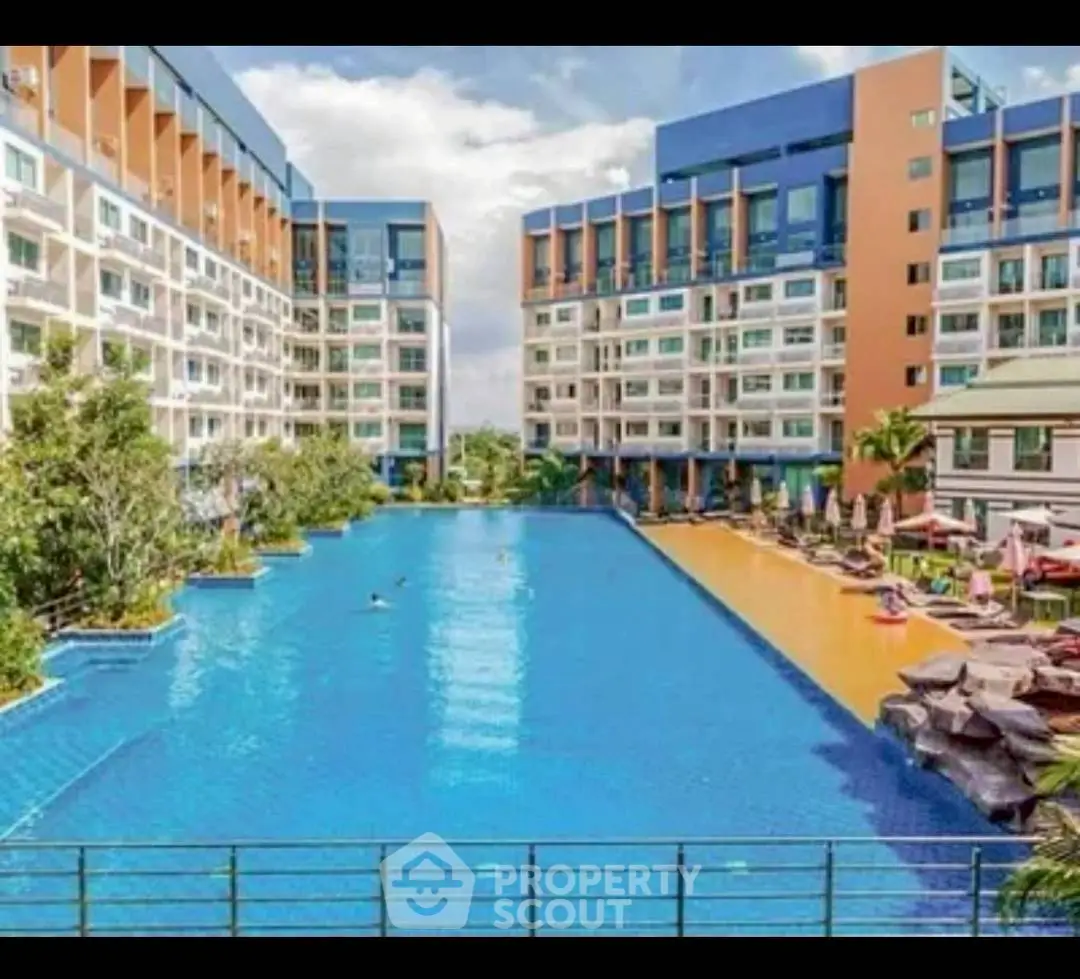 Luxurious residential complex with expansive swimming pool and modern architecture.