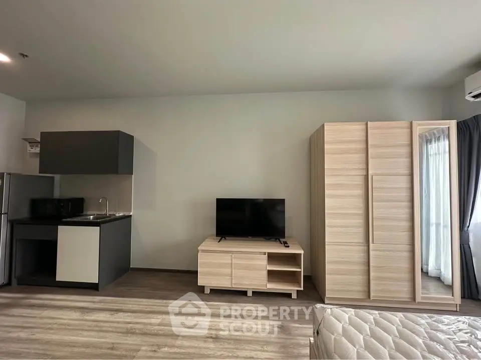 Modern studio apartment with sleek kitchen and cozy living area