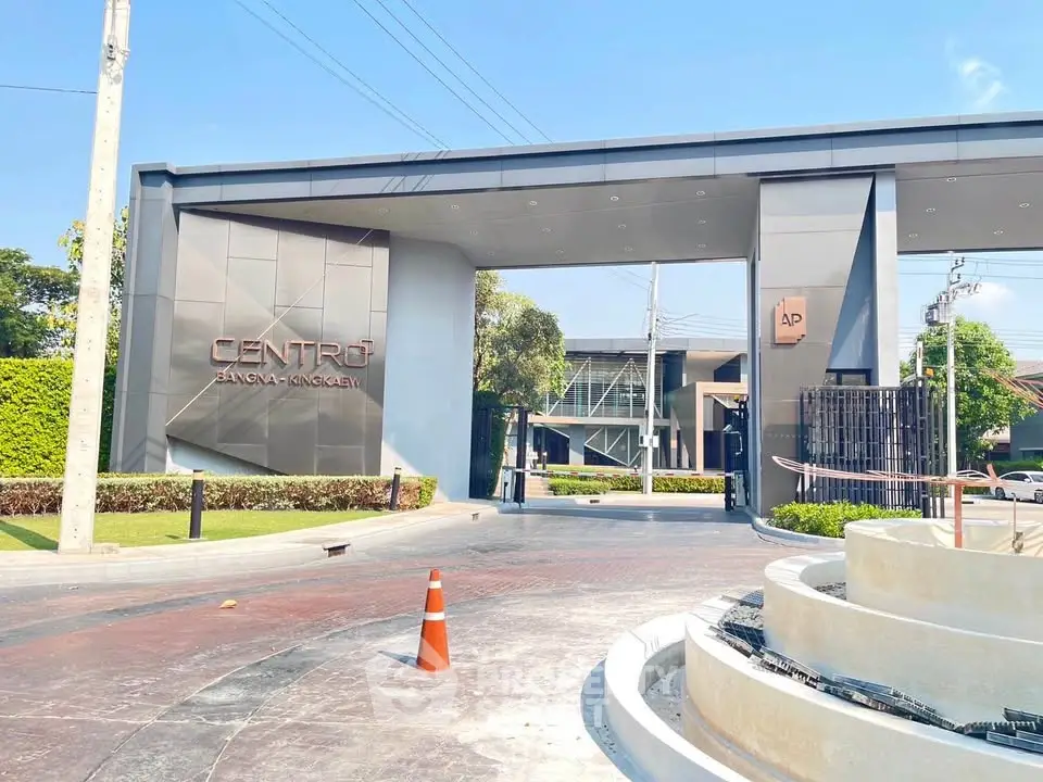 Modern gated entrance of luxury residential community with sleek design and lush greenery.