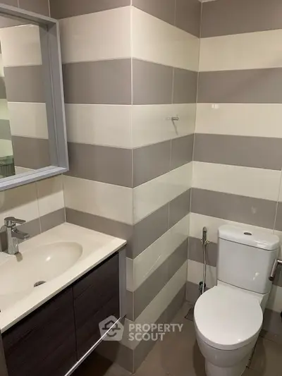 Modern bathroom with sleek fixtures and striped tile design