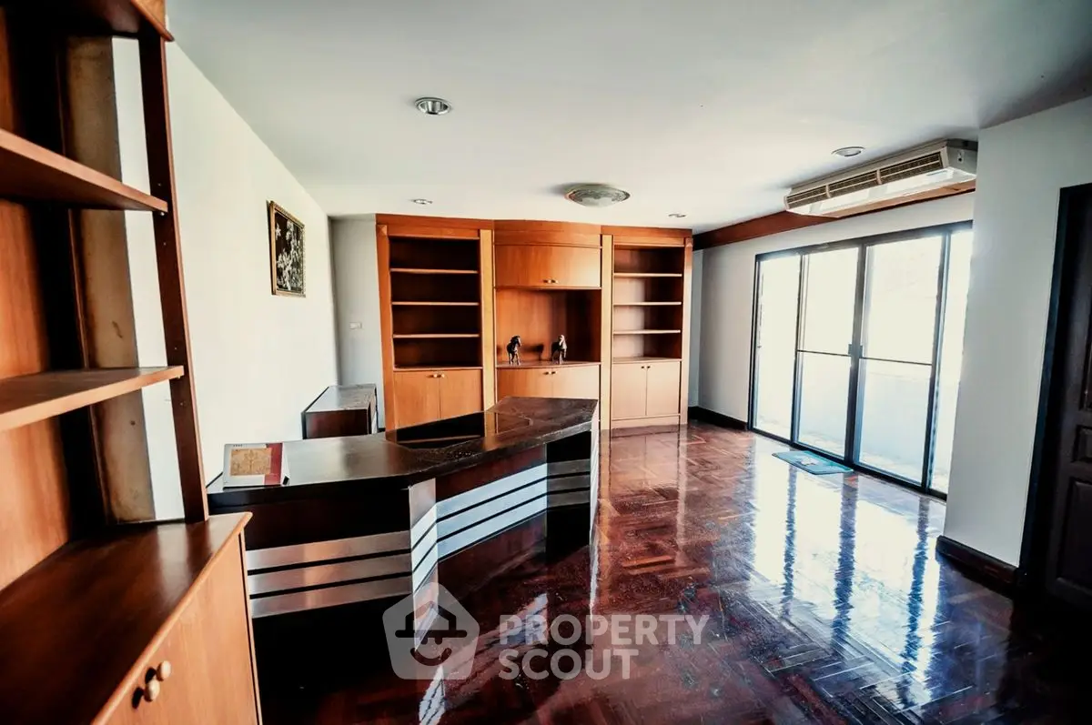 Spacious study room with wooden shelves and large windows for natural light.