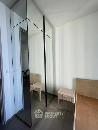 Modern bedroom with mirrored closet and minimalist furniture