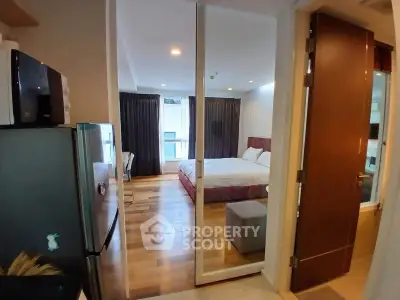 Modern studio apartment with cozy bedroom and sleek kitchen appliances