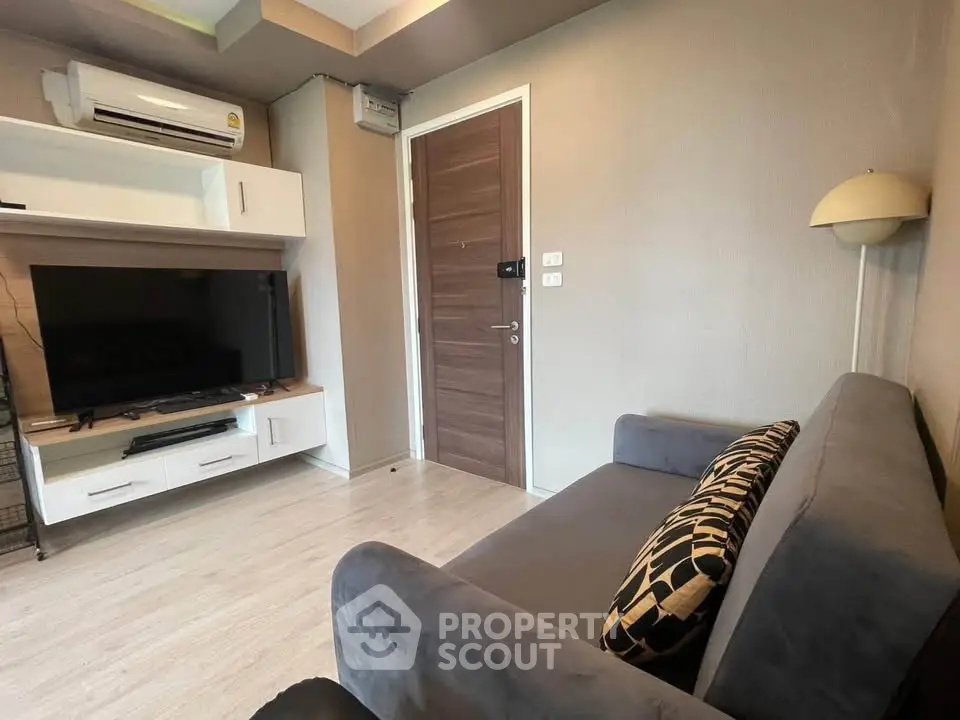 Modern living room with sleek TV setup and cozy sofa in stylish apartment.