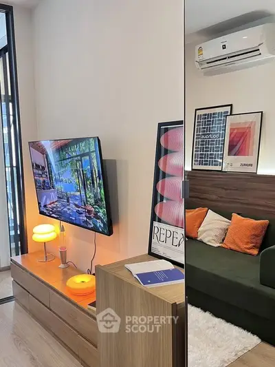 Modern living room with stylish decor, wall-mounted TV, and cozy seating area, perfect for relaxation.