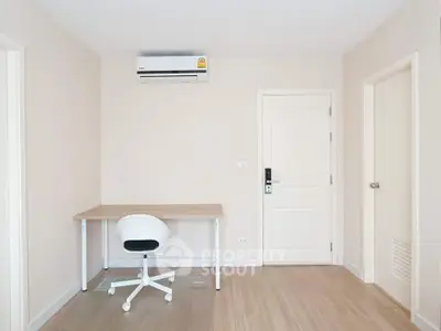 Minimalist study room with desk, chair, and air conditioning in modern apartment.