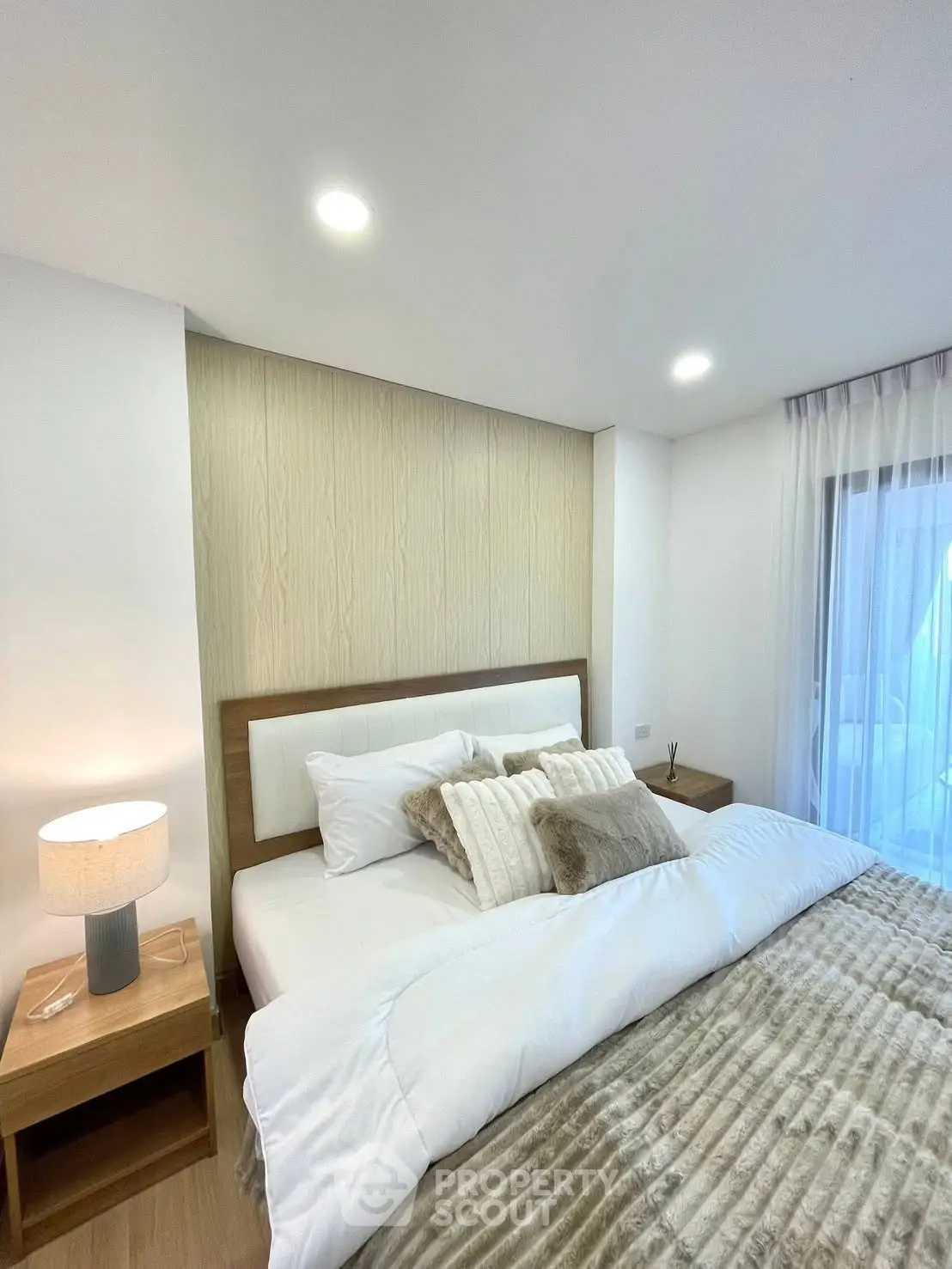Modern bedroom with cozy bedding and stylish decor in a bright apartment.