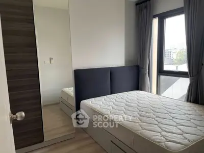 Modern bedroom with large window and mirrored wardrobe in a stylish apartment.