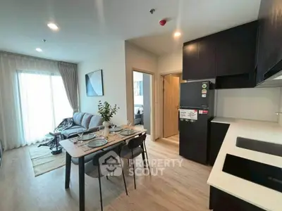 Modern open-plan living room and kitchen with stylish decor and natural light.
