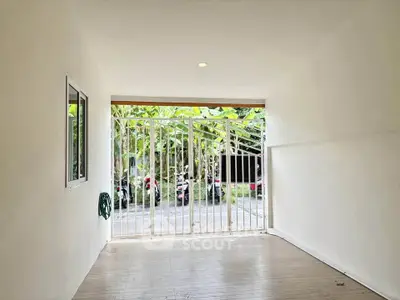 Spacious garage with secure gate and natural light, ideal for parking or storage.
