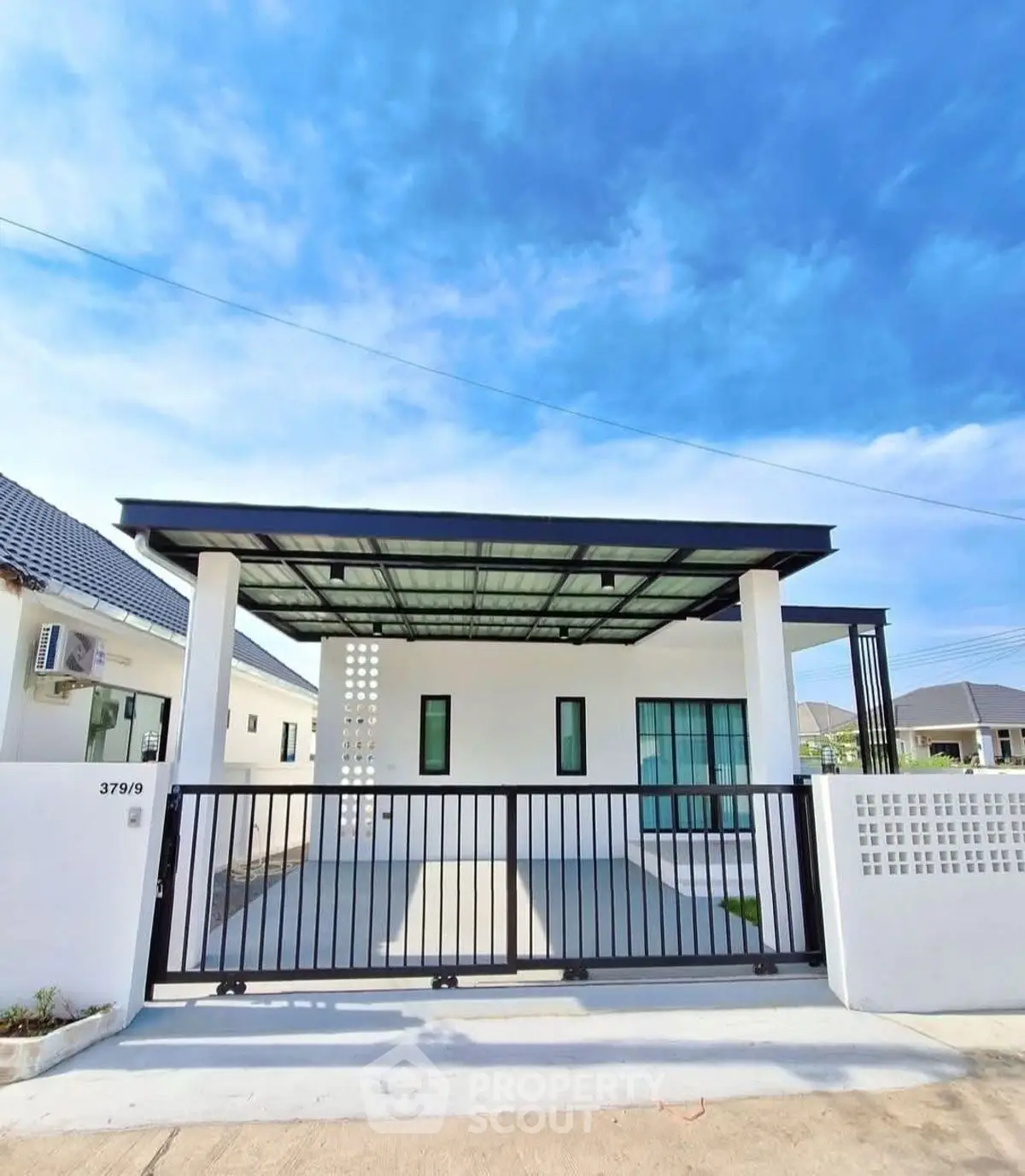 Modern single-story house with sleek design and spacious driveway under a clear blue sky.