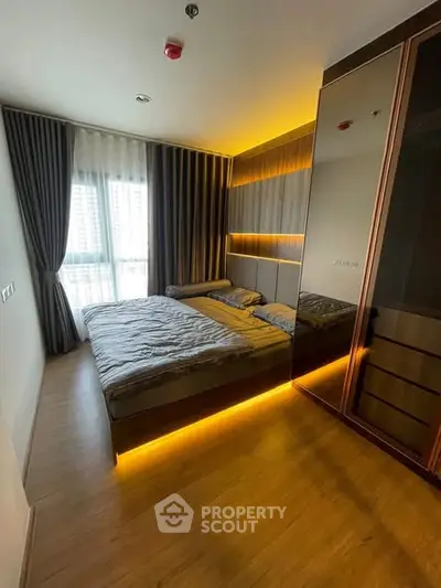 Modern bedroom with ambient lighting and large mirrored wardrobe