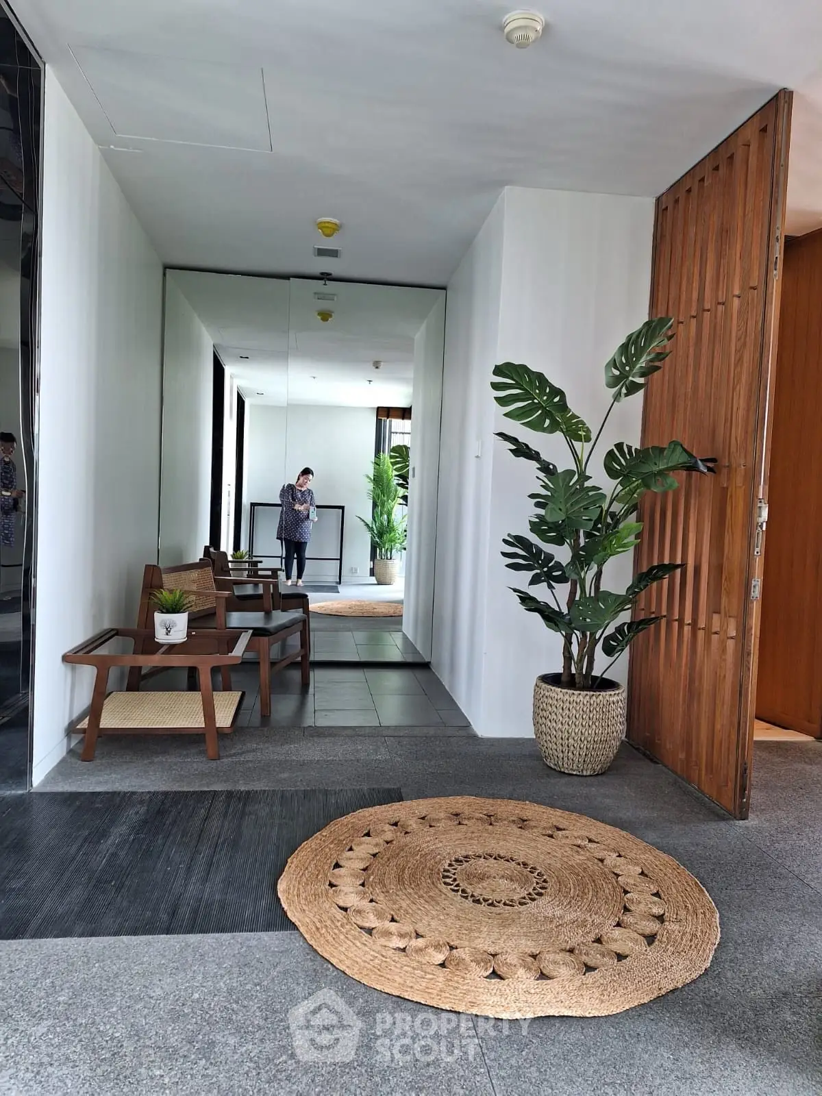 Stylish entrance with modern decor and natural elements, featuring a cozy seating area and decorative plants.