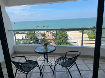 Stunning ocean view from a spacious balcony with seating area, perfect for relaxation.
