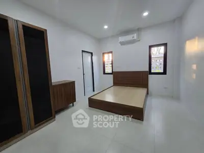 Spacious bedroom with modern wooden furniture and air conditioning