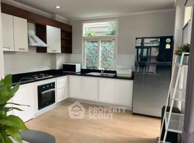 Modern kitchen with sleek appliances and open layout, featuring a gas stove and ample natural light.