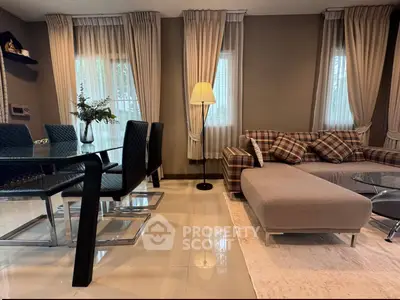 Stylish living room with modern dining area and cozy seating, featuring elegant decor and natural light.