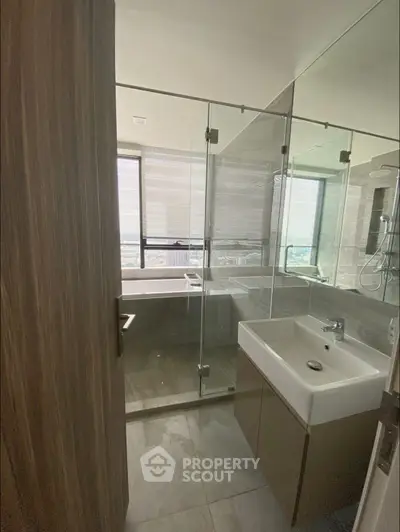 Modern bathroom with glass shower and city view