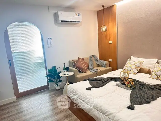 Chic bedroom with cozy seating area and modern decor, perfect for relaxation and comfort.