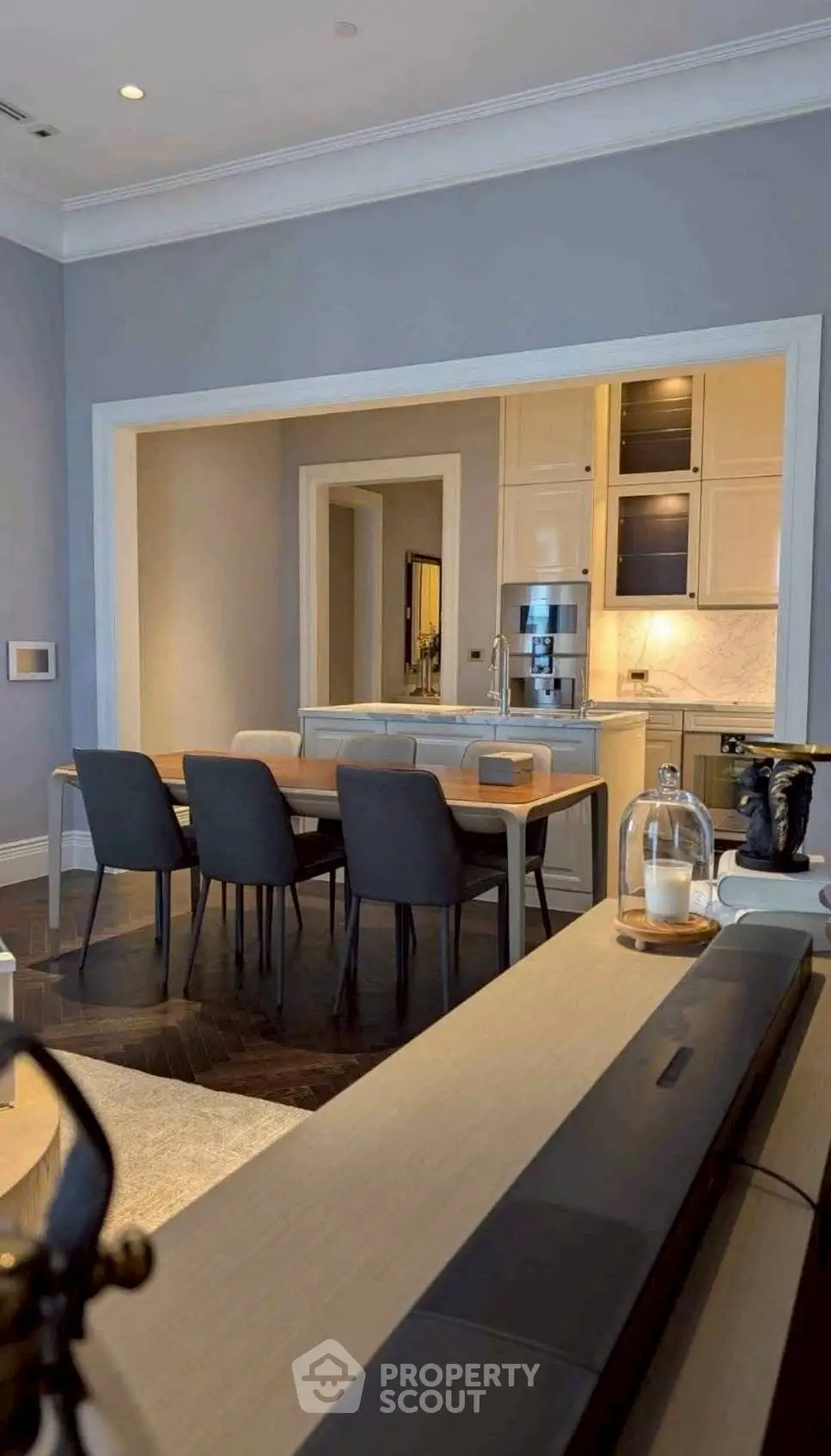 Elegant dining area with modern furniture and open kitchen layout in a stylish apartment.