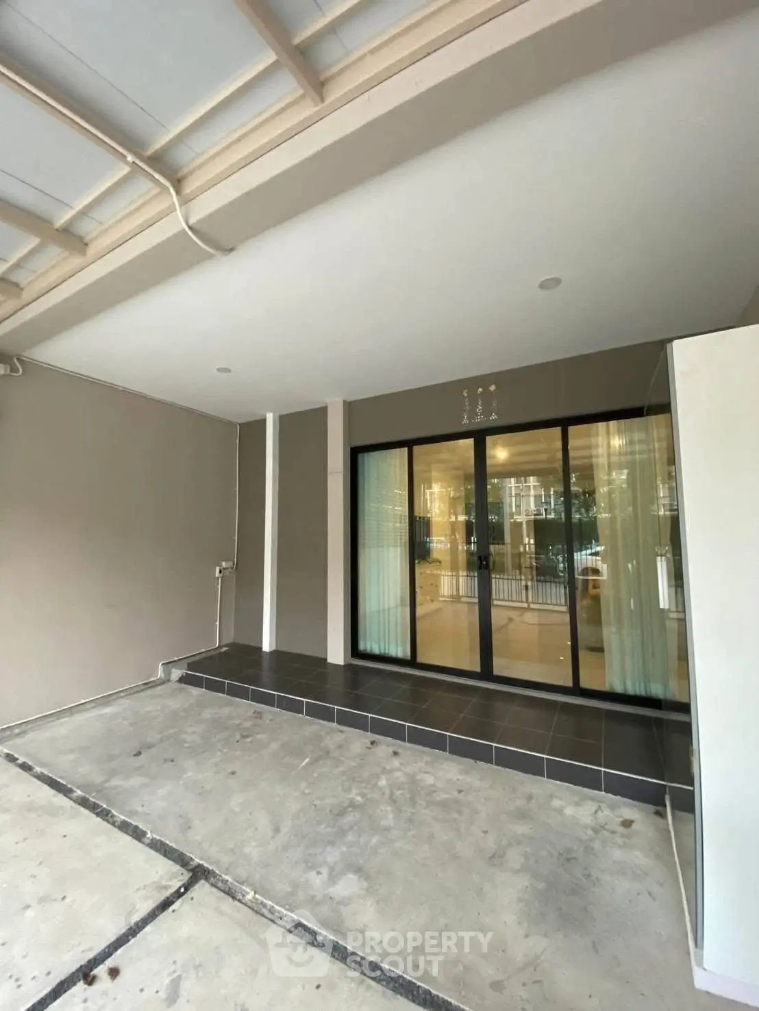 Spacious covered patio with sliding glass doors leading to modern interior