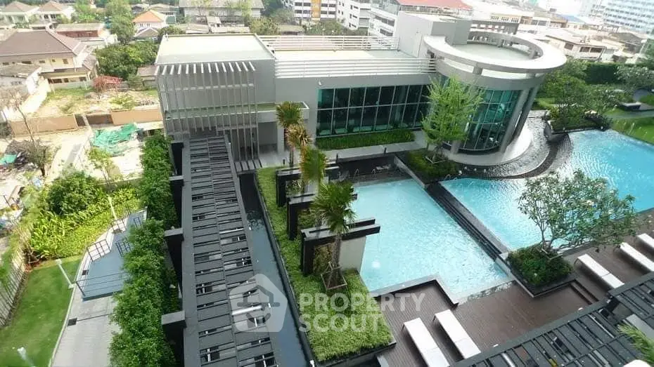 Luxurious rooftop pool with modern architecture and lush greenery in urban setting.