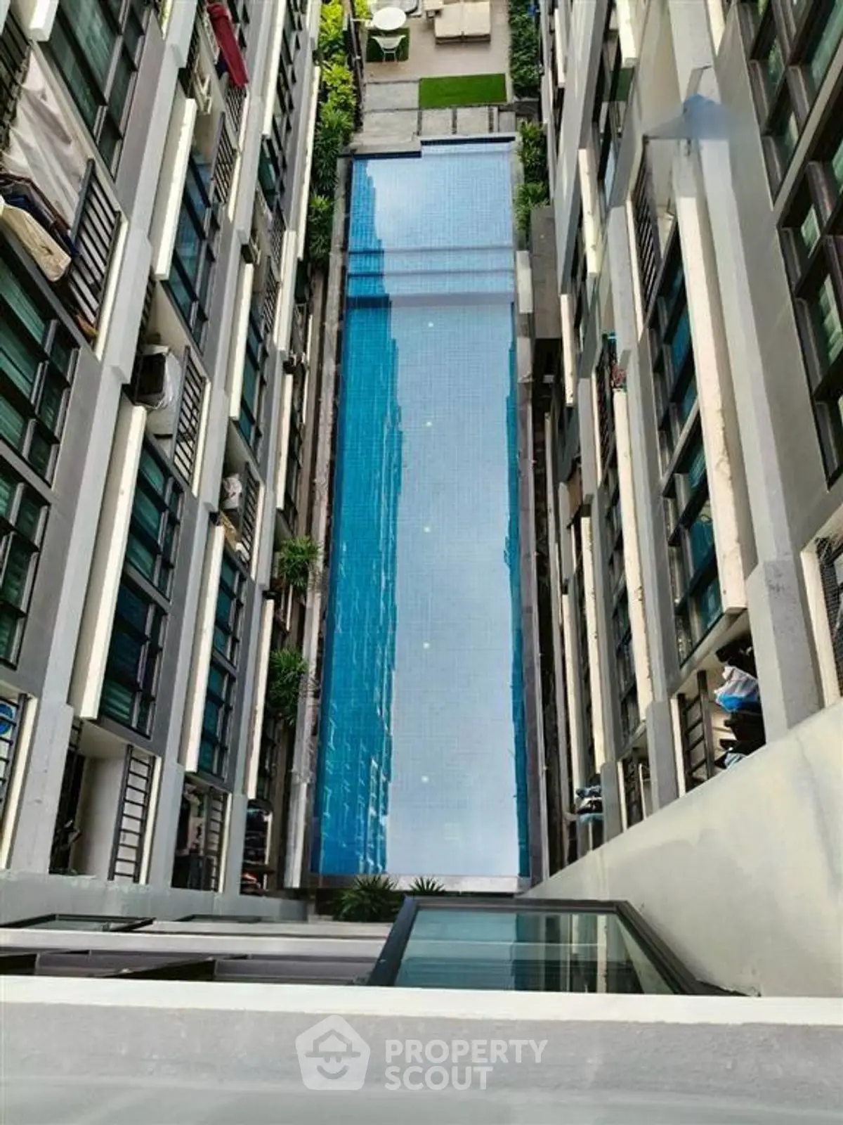 Stunning aerial view of a modern apartment complex with a sleek swimming pool.