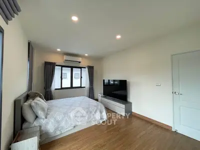 Spacious bedroom with modern decor and large windows for natural light