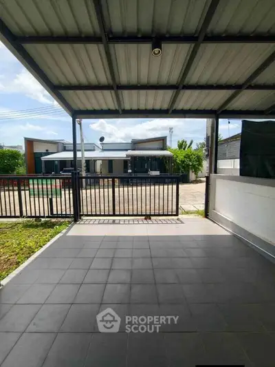 Spacious covered patio with modern design overlooking a serene neighborhood street.