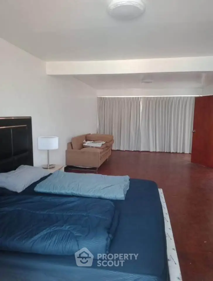 Spacious bedroom with cozy bed and seating area, perfect for relaxation and comfort.