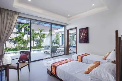 Luxurious bedroom with pool view and modern decor, featuring twin beds and elegant furnishings.