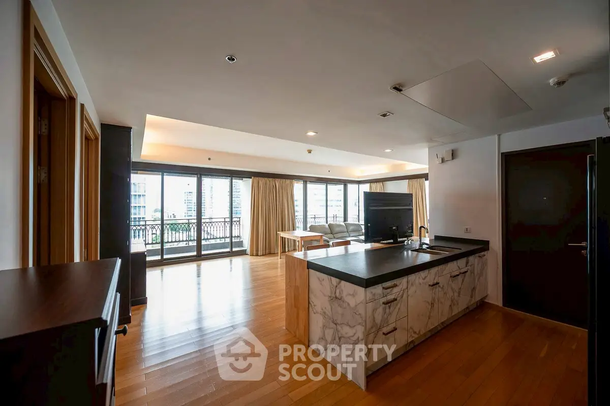 Spacious open-plan living room with modern kitchen and balcony view