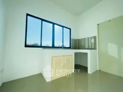 Bright kitchen space with large window and modern cabinetry