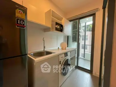 Modern kitchen with washing machine and balcony view in stylish apartment