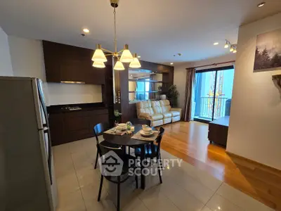 Modern open-layout living room with kitchen, dining area, and balcony access in a stylish apartment.