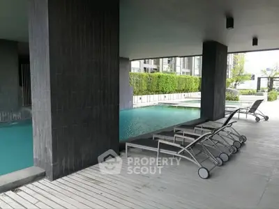 Luxurious modern poolside area with sleek lounge chairs and serene ambiance.