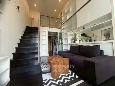 Stylish modern loft with black staircase and cozy living area