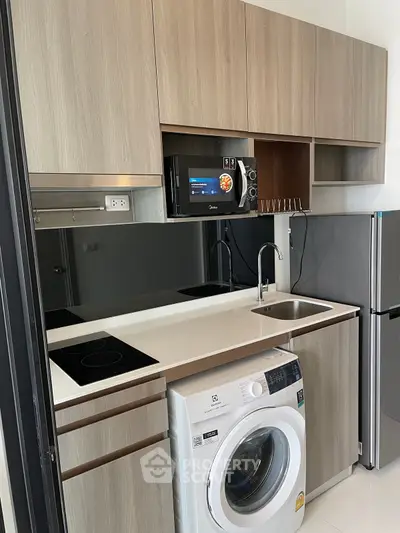 Modern compact kitchen with washing machine and sleek appliances