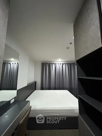 Modern bedroom with sleek design, featuring a comfortable bed, stylish desk, and ample storage space.