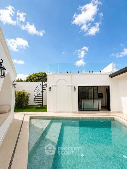 Luxurious villa with private pool and rooftop terrace under clear blue sky.