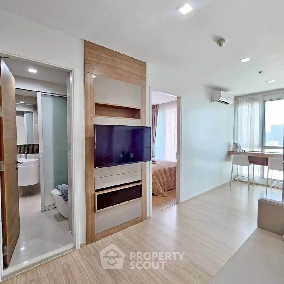 Modern apartment interior with open living space, bedroom, and bathroom, featuring sleek design and natural light.