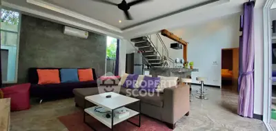 Spacious modern living room with stylish decor and open kitchen layout, featuring a cozy seating area and contemporary staircase.
