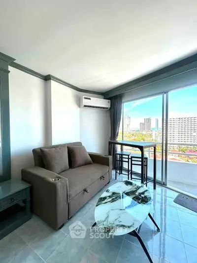 Modern living room with city view, featuring a stylish sofa and marble coffee table.