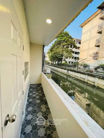 Charming balcony with canal view in urban residential area, perfect for relaxation and enjoying the outdoors.