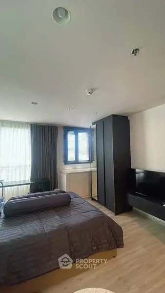 Modern bedroom with stylish decor and ample natural light